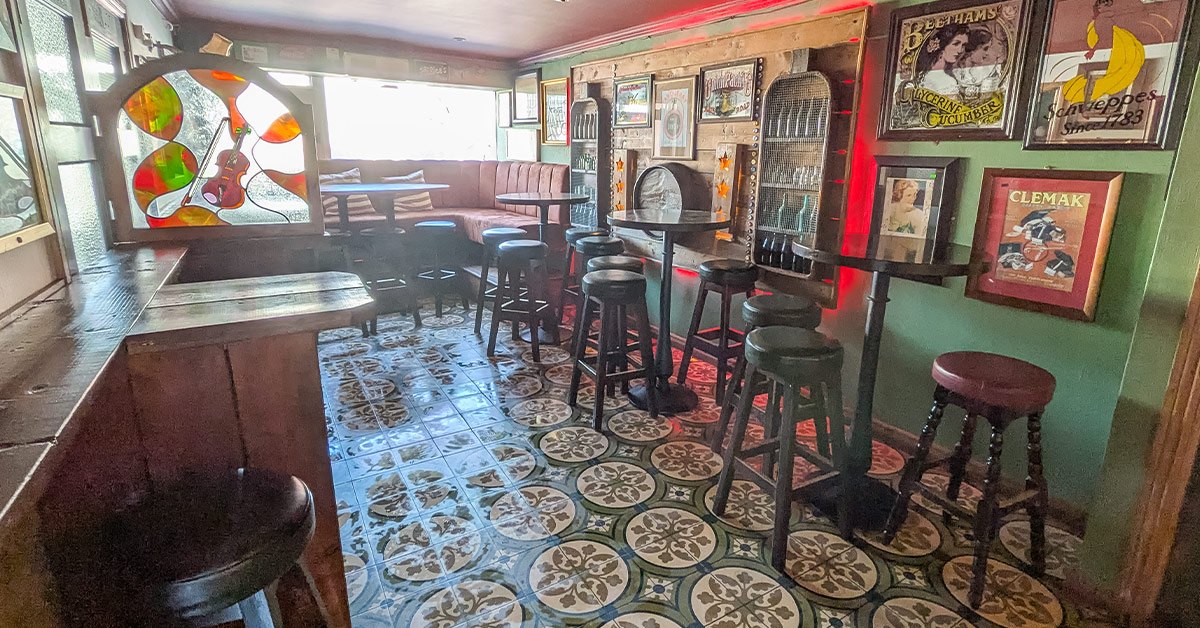 Tables, bar stools and vintage framed signs in The Back Bar