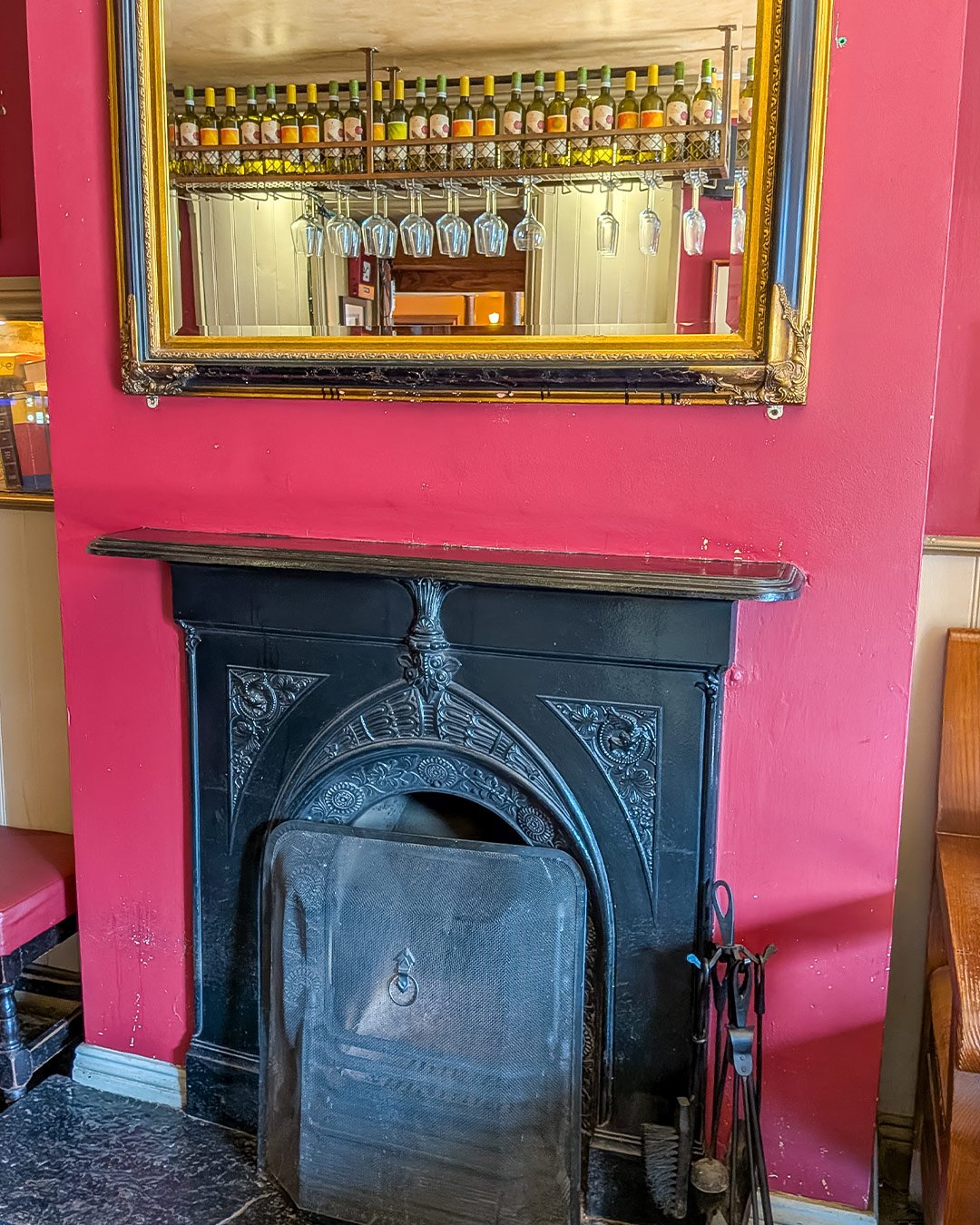 The traditional fireplace in the Front Room, beneath a whiskey display