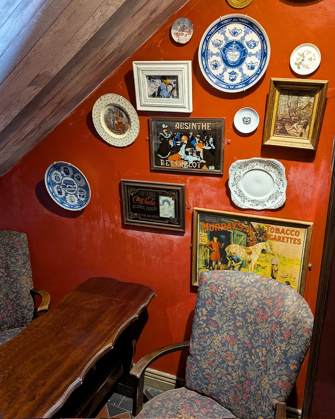 The Front Room with cushioned seats, a round table and framed photographs